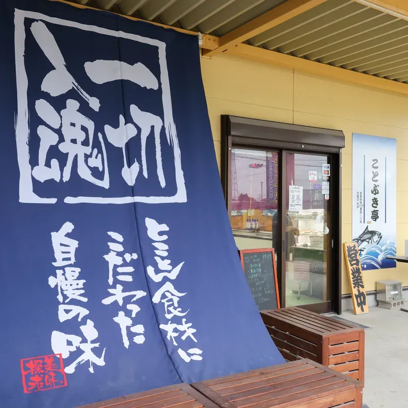 「とことん食材にこだわった自慢の味」と書かれたのれんと入口